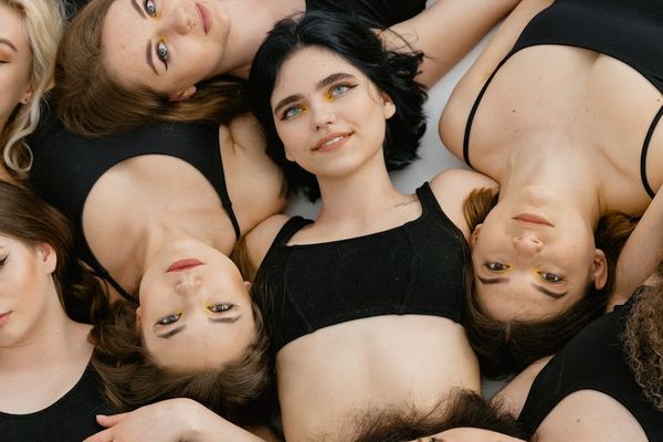 Diverse group of people smiling in a bright yoga studio.